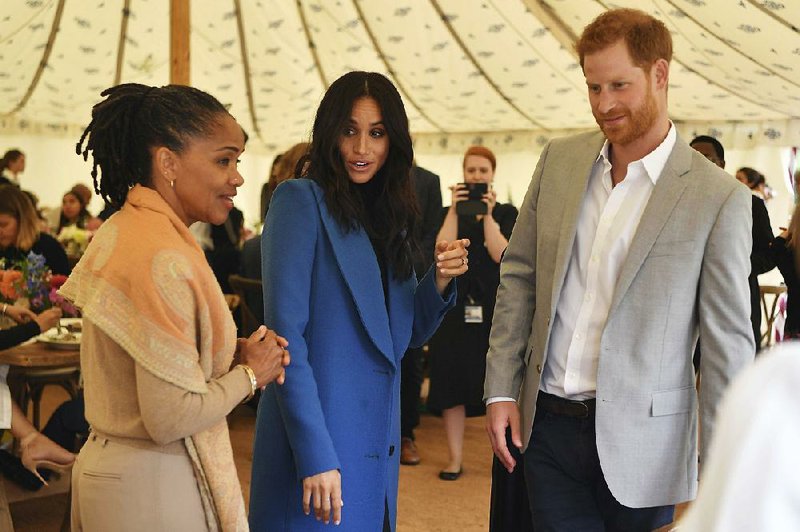 Meghan, the Duchess of Sussex, center, talks to her mother Doria Ragland, with Prince Harry at right, as they attend  a reception for the cookbook "Together", at Kensington Palace, in London, Thursday Sept. 20, 2018.