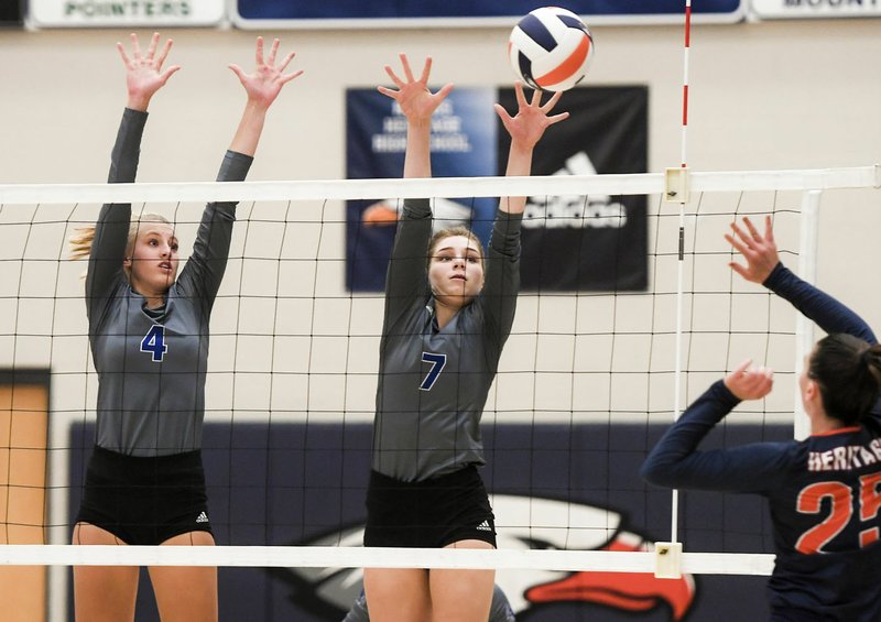 NWA Democrat-Gazette/CHARLIE KAIJO Rogers High School Kate Miller (4) and Anna Randels (7) block during a volleyball game, Thursday, September 20, 2018 at Heritage High School War Eagle arena in Rogers.
