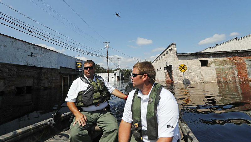 James Mills (left) and Cody Britt of the South Carolina Department of Natural Resources patrol floodwaters Friday in Nichols, S.C. The town is virtually inaccessible except by boat, much as it was two years ago when it was flooded by Hurricane Matthew.