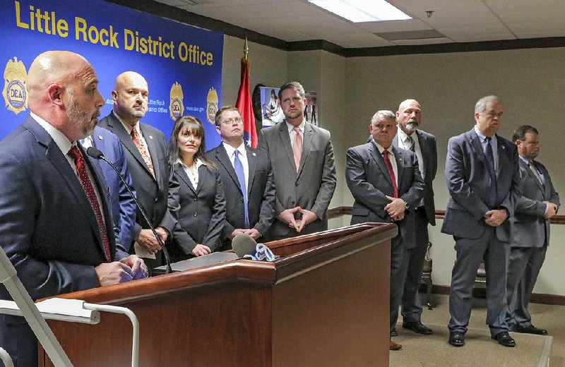 Justin King (left), the federal Drug Enforcement Administration’s assistant special agent in charge, announces the arrest of more than 1,200 people in a two-month operation against illegal drugs. Other state, local and federal officials were also on hand Friday in Little Rock. 