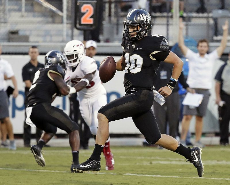 Central Florida quarterback McKenzie Milton runs for a 12-yard touchdown against Florida Atlantic during the first half Friday in Orlando, Fla. Milton passed for 306 yards and 3 touchdowns in a 56-36 victory. 