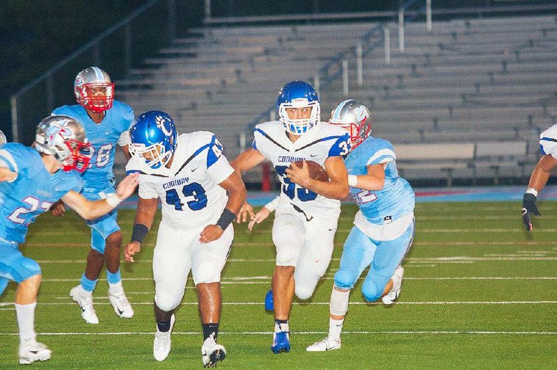 Cary McClain (33) of Conway follows the blocking of Nick Tufu (43) on his way to a first down during the first half Friday against Fort Smith Southside in Fort Smith. Conway won 45-19. 