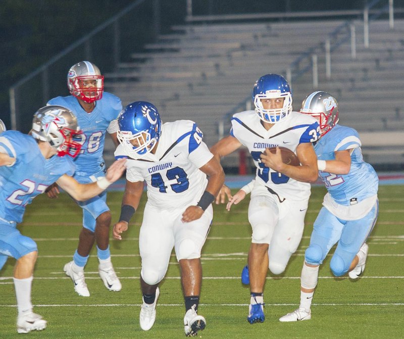 #33 Cary McClain of Conway follows the blocking of #43 Nick Tufu on his way to a first down during the first half.