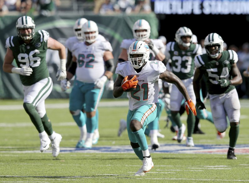 In this Sunday, Sept. 16, 2018, file photo, Miami Dolphins running back Frank Gore (21) carries the ball against the New York Jets during an NFL football game in East Rutherford, N.J. Running backs Frank Gore and Oakland's Marshawn Lynch are still going strong in their 30s. The two teams meet on Sunday. (Brad Penner/AP Images for Panini, File)