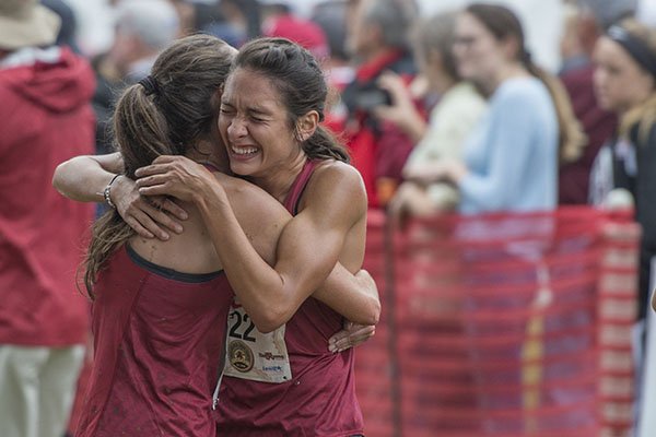 Carina Viljoen (left) and Taylor Werner embrace Saturday Sept. 22, 2018, after finishing the collegiate women's 5K race at the 30th annual Chile Pepper Cross Country Festival in Fayetteville.