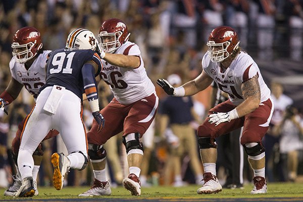 Arkansas offensive linemen Johnny Gibson (62), Ty Clary (66) and Hjalte Froholdt (51) fall into pass protection while Auburn defensive lineman Nick Coe (91) applies pressure during a game Saturday, Sept. 22, 2018, in Auburn, Ala. Froholdt and Clary swapped positions for the game, a move that is expected to continue in future weeks. 