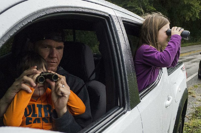 Blake Bowers of Conway helps his son Jordan, 4, adjust his binoculars Saturday while Bella Bowers, 5, already has the Boxley Valley elk in sight from the back seat. 
