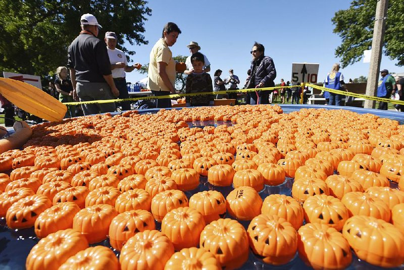 Pumpkin replicas float in a pool Saturday for an event at the Fall Festival in downtown St. Joseph, Mich. 