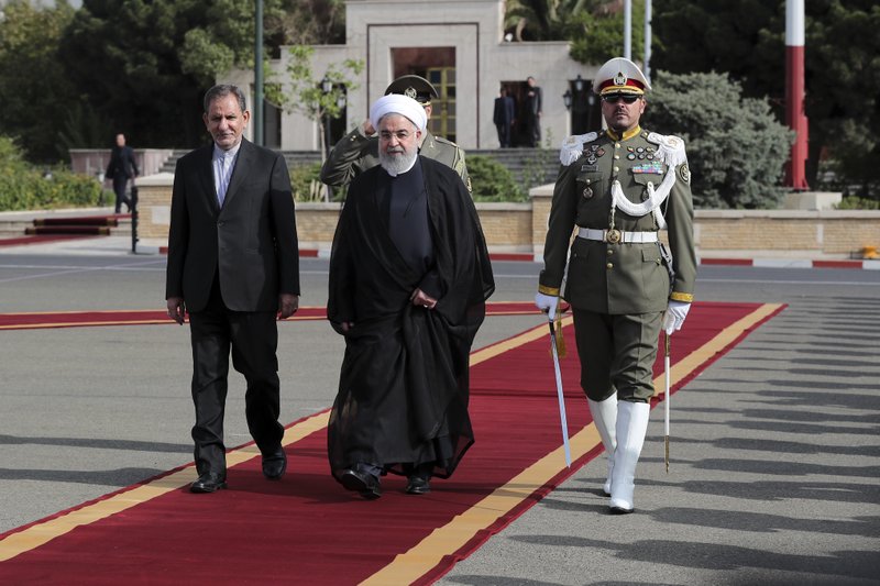 In this photo released by official website of the office of the Iranian Presidency, President Hassan Rouhani, center, leaves for New York to attend the United Nations General Assembly, at Mehrabad Airport in Tehran, Iran, Sunday, Sept. 23, 2018. On Saturday, the same day Arab separatists killed at least 25 people in an attack targeting a military parade in Iran, Rudy Giuliani, President Donald Trump&#x2019;s lawyer, declared that the government would be toppled. Iran fears that America and its Gulf Arab allies are plotting to tear the Islamic Republic apart. (Iranian Presidency Office via AP)