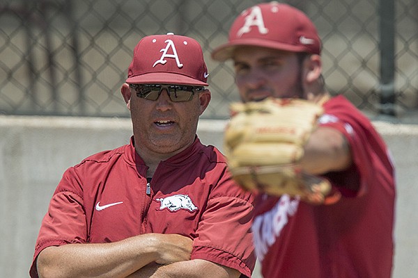 Arkansas pitching coach Wes Johnson (left) watches as Zebulon Vermillion throws in the bullpen Friday, June 8, 2018, during practice for the NCAA Fayetteville Super Regional at Baum Stadium. 