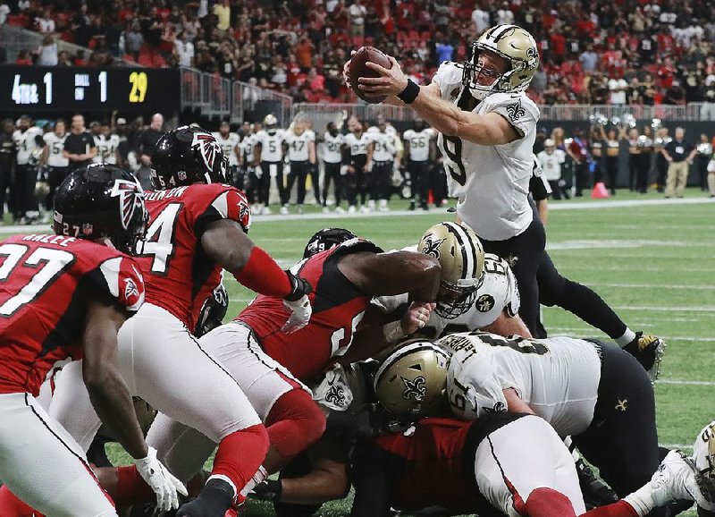 New Orleans Saints quarterback Drew Brees goes over the top for the winning touchdown in overtime to beat the Atlanta Falcons 43-37 on Sunday in Atlanta. Brees passed for 396 yards and 3 touchdowns and ran for 2 scores.
