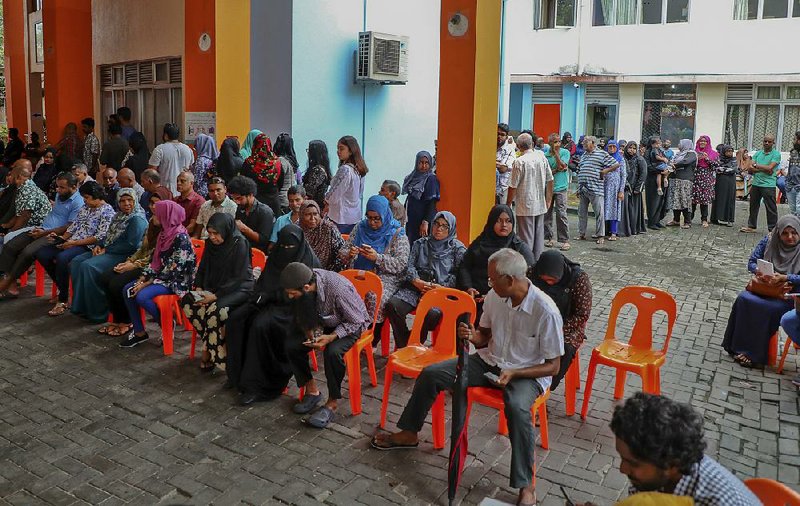 Residents in the Maldives’ capital city, Male, wait to cast their ballots in Sunday’s presidential election.