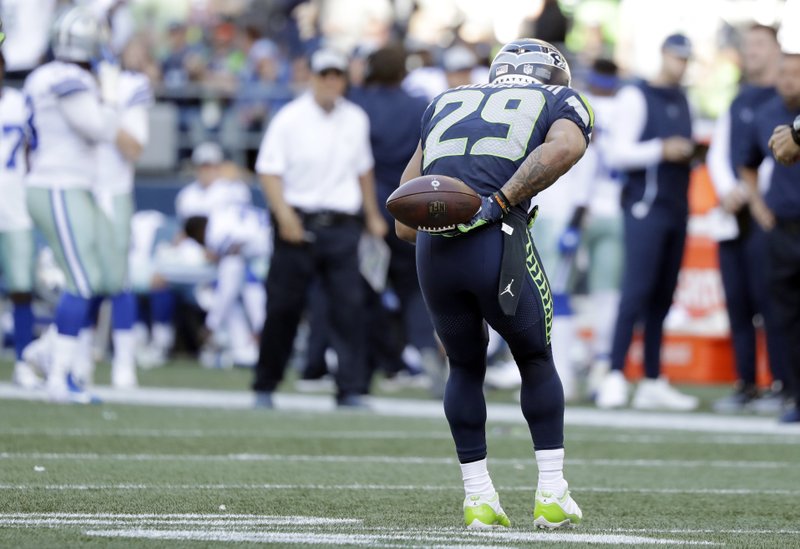 Seattle Seahawks free safety Earl Thomas bows in the direction of the Dallas Cowboys bench after he intercepted a pass during the second half of an NFL football game, Sunday, Sept. 23, 2018, in Seattle. It was Thomas' second interception of the game. (AP Photo/Elaine Thompson)