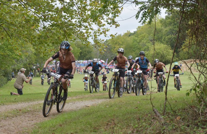 Jackson Springmann (left) of Bentonville West High School leads the start of the sophomore race, Sunday, Sept. 23, 2018 during a National Interscholastic Cycling Association race at Slaughter Pen trail in Bentonville. The second race of the fall NICA racing league.