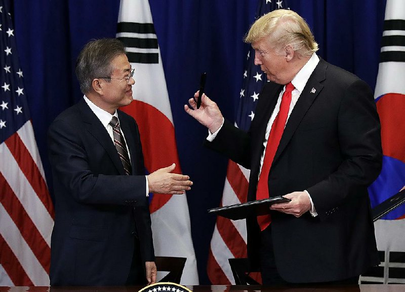 President Donald Trump hands a pen he used to South Korean President Moon Jae-In at a signing ceremony for the United States-Korea Free Trade Agreement at the Lotte New York Palace hotel during the United Nations General Assembly on Monday in New York.