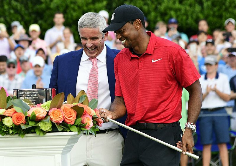 Tiger Woods (right) is handed the trophy after winning the Tour Championship on Sunday in Atlanta. Woods won for the first time in more than five years, creating more excitement for the Ryder Cup.