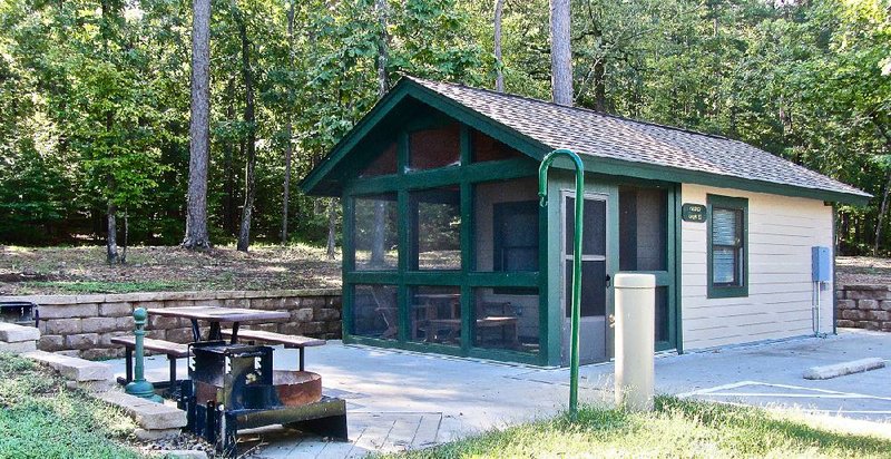 At Lake Ouachita State Park, outdoor amenities of camper cabins include a screened porch with furniture, two grills and a picnic table. 