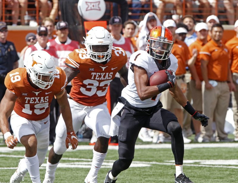 FILE - In this Oct. 21, 2017, file photo, Oklahoma State receiver Jalen McCleskey (1) runs after a catch against Texas defenders Brandon Jones (15) and Gary Johnson (33) during the second half of an NCAA college football game in Austin, Texas. A new NCAA policy that makes it easier to redshirt football players comes with an unintended consequence: Players can now leave their teams after playing four games with plans to transfer and take the saved year of eligibility to a new school. Several upperclassmen who would have been out of eligibility had they kept playing this season have already taken this route, including McCleskey. (AP Photo/Michael Thomas, File)