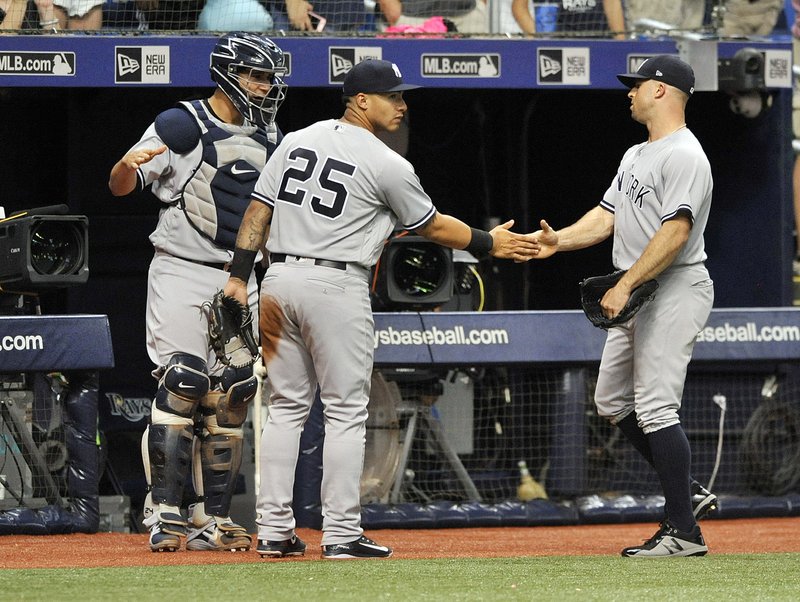 New York Yankees' Gary Sanchez, left, and Gleyber Torres (25) congratulate Brett Gardner after his leaping catch on the warning track of a fly ball hit by Tampa Bay Rays' Brandon Lowe to end the sixth inning of a baseball game Monday, Sept. 24, 2018, in St. Petersburg, Fla. (AP Photo/Steve Nesius)