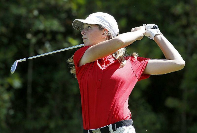 Magnolia’s Meghan Lindsey watches an iron shot Tuesday at Big Sugar Golf Club in Pea Ridge. Lindsey shot a 73 and won the Class 4A girls state golf championship.  