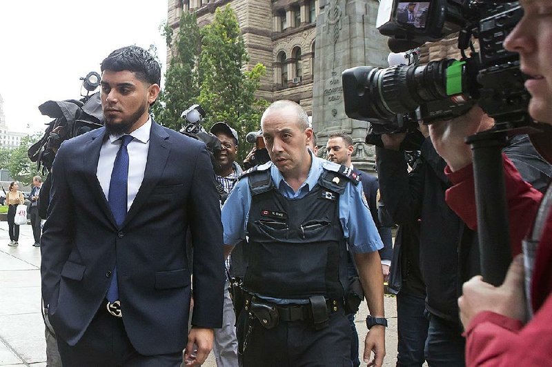 Houston Astros' Roberto Osuna, left, leaves a Toronto court, Tuesday, Sept. 25, 2018. 