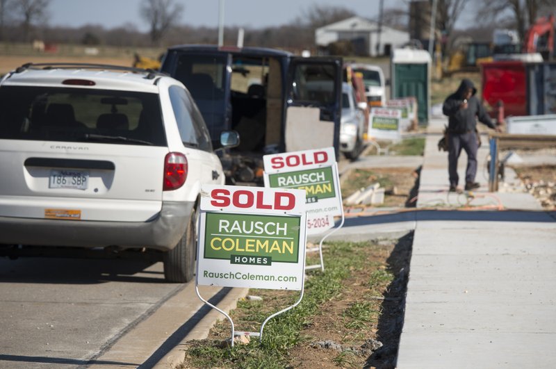 NWA Democrat-Gazette/CHARLIE KAIJO Sold signs are displayed in front of unfinished homes on Dec. 11 at the new Rausch Coleman development in Bentonville.