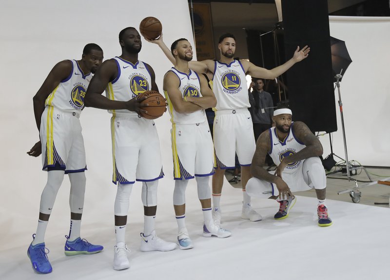 Golden State Warriors' Kevin Durant, from left, Draymond Green, Stephen Curry, Klay Thompson and DeMarcus Cousins poses for photos for the team's photographer during media day at the NBA basketball team's practice facility in Oakland, Calif., Monday, Sept. 24, 2018. (AP Photo/Jeff Chiu)