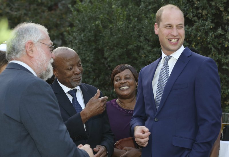 Britain's Prince William, right, talks with guests, Namibian Finance Minister Calle Schlettwein, left, and Namibian Vice President Nangolo Mbumba. second from left, at the British High Commissioner residence in Windhoek, Namibia, Tuesday, Sept. 25, 2018.  