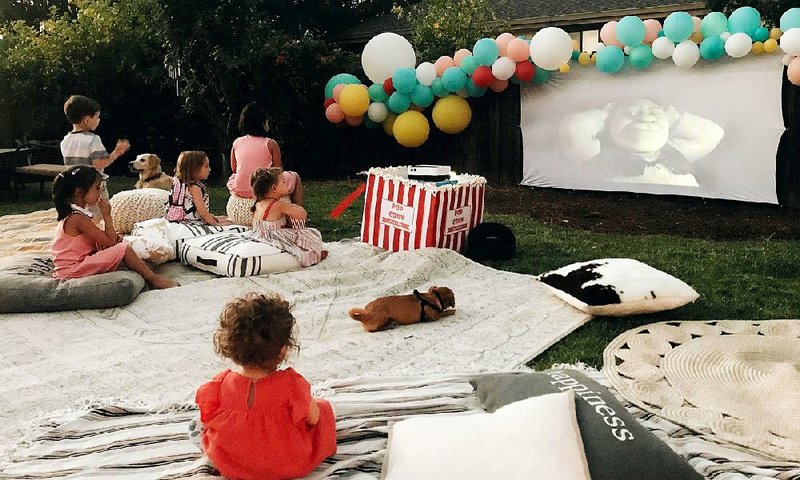 Children at a backyard birthday party watch the movie Shrek on an outdoor theater in Concord, Calif. 
