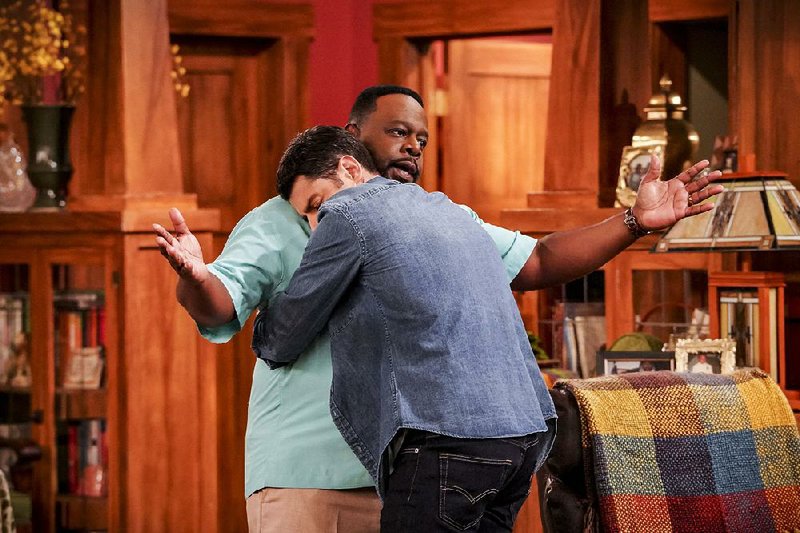 Bring it in! Exceedingly friendly Dave Johnson (Max Greenfield, back to camera) greets curmudgeon Calvin Butler (Cedric “The” Entertainer) on The Neighborhood. The new sitcom debuts Monday on CBS. 