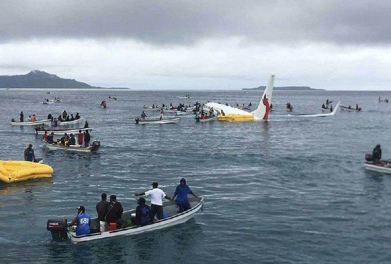 Fishing boats pick up passengers and crew members of an Air Niugini flight that crashed into a Pacific lagoon on its approach Friday to Chuuk International Airport in Micronesia. All 47 people on the plane survived the crash. 