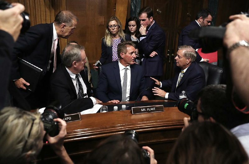 Republican Sens. Mike Crapo (from left), Jeff Flake and Lindsey Graham talk Friday during a Judiciary Committee meeting, where Flake led an effort to delay the full Senate vote on Brett Kavanaugh’s Supreme Court nomination. 