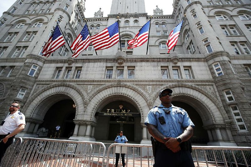 Officers stand guard at the Trump International Hotel in Washington in June. The hotel is among properties belonging to President Donald Trump that benefit from investments or business from foreign governments.