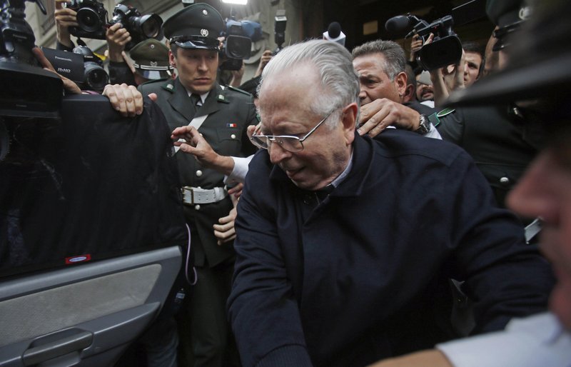 FILE - In this Nov. 11, 2015 file photo, Fernando Karadima is escorted from a court, after testifying in a case that three of his victims brought against the country's Catholic Church in Santiago, Chile. Pope Francis has on Friday, Sept. 29, 2018, defrocked Karadima, a priest at the center of the global sex abuse scandal rocking his papacy, invoking his &quot;supreme&quot; authority to stiffen a sentence originally handed down by a Vatican court in 2011. (AP Photo/Luis Hidalgo, File)