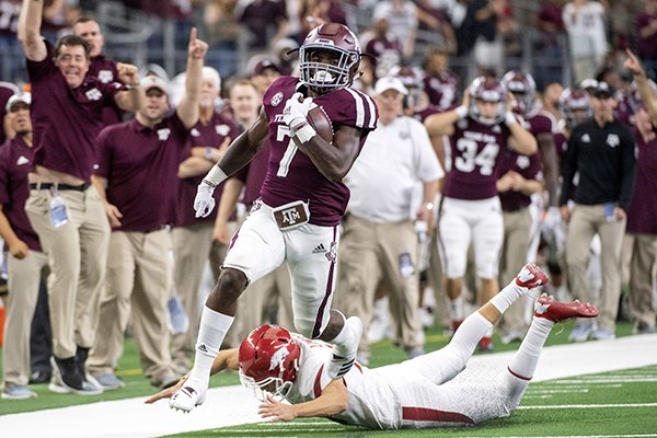 Texas A&M kick returner Jashaun Corbin (7) avoids the diving tackle of Arkansas kicker Connor Limpert as he returns the opening kickoff for a touchdown during the first quarter of an NCAA college football game Saturday, Sept. 29, 2018, in Arlington, Texas. (AP Photo/Jeffrey McWhorter)