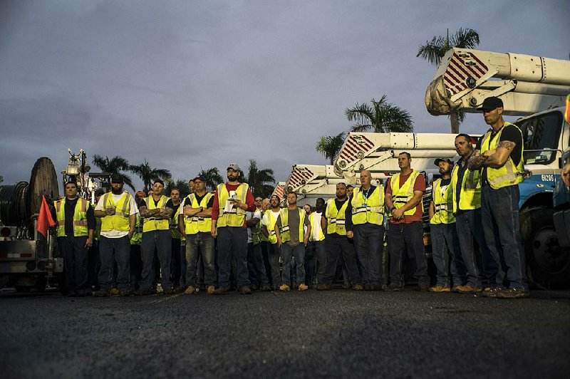 Utility crews from the mainland muster for a safety meeting on Feb. 18 in San Juan, Puerto Rico. Utilities that helped restore power on a nonprofit basis have been astonished to receive hefty tax bills from Puerto Rican cities.