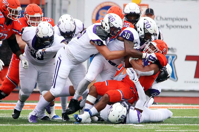 UCA linebacker Raphael Garner (30) and defensive lineman Austin Norris (86) help bring down a Sam Houston State ball carrier Saturday during the Bears’ overtime loss to the Bearkats in Huntsville, Texas. 