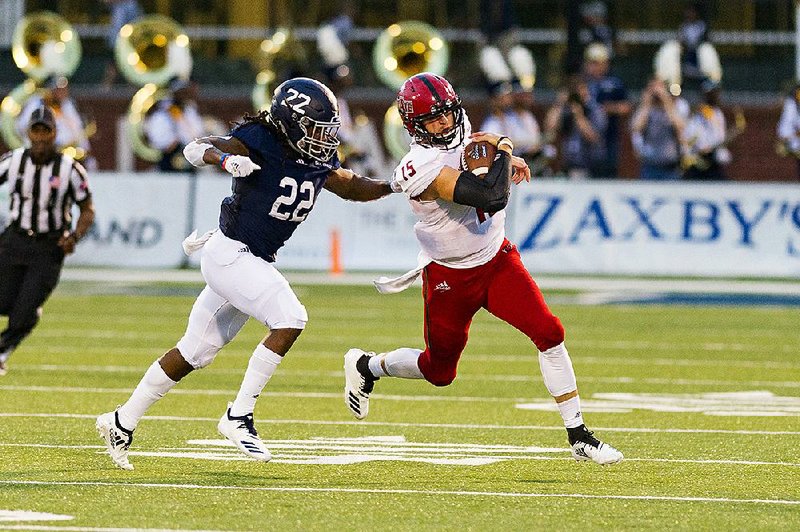 Arkansas State quarterback Justice Hansen runs with the ball Saturday while trying to elude Georgia Southern safety Joshua Moon during the Red Wolves’ 28-21 loss to the Eagles in Statesboro, Ga. 