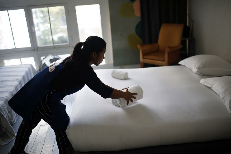 In this September photo, a cleaning lady works in an apartment listed on Airbnb in Paris. 