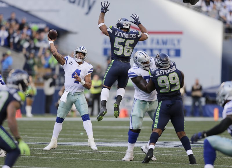 In this Sept. 23, 2018, file photo, Seattle Seahawks linebacker Mychal Kendricks (56) leaps as Dallas Cowboys quarterback Dak Prescott (4) attempts a pass during the second half of an NFL football game in Seattle.  (AP Photo/John Froschauer, File)