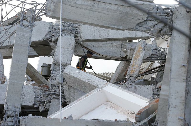 A rescuer in Palu, Indonesia, on Sunday looks through the Roa-Roa Hotel, which was damaged by Friday’s earthquake and resulting tsunami. The national disaster agency said the official death toll had increased to more than 800, with Palu suffering most of the casualties.