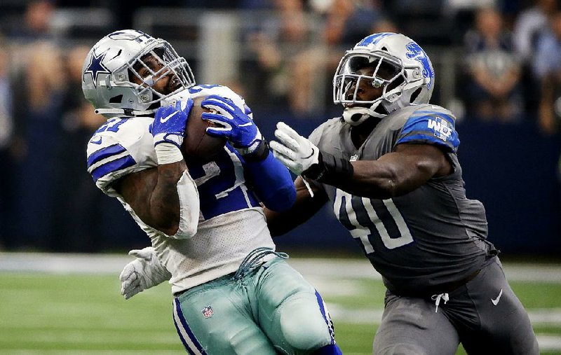 Dallas Cowboys running back Ezekiel Elliott catches a pass in front of Detroit Lions linebacker Jarrad Davis in the second half Sunday in Arlington, Texas. The catch set up Brett Maher’s 38-yard field goal as time expired to give the Cowboys a 26-24 victory.