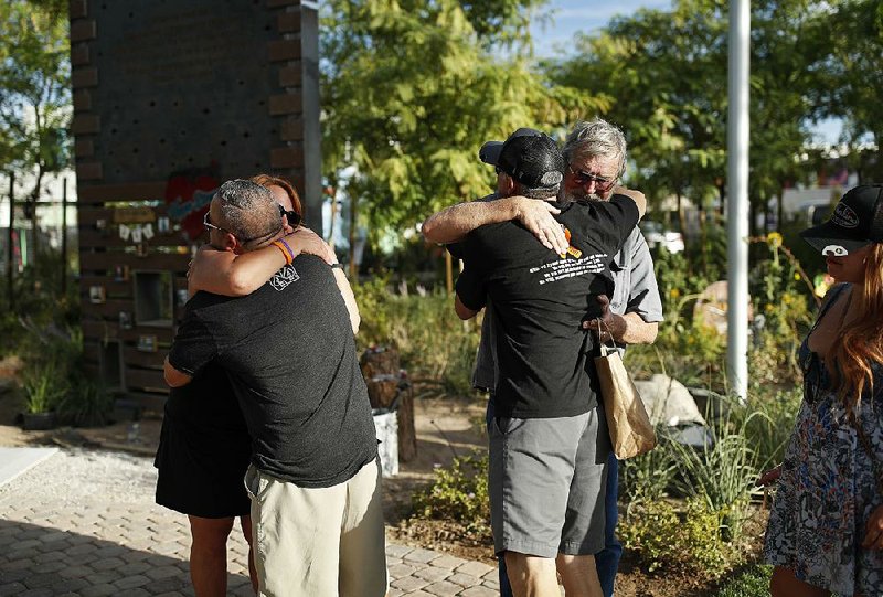 People embrace Friday at a memorial garden for victims of the Oct. 1, 2017, mass shooting in Las Vegas.