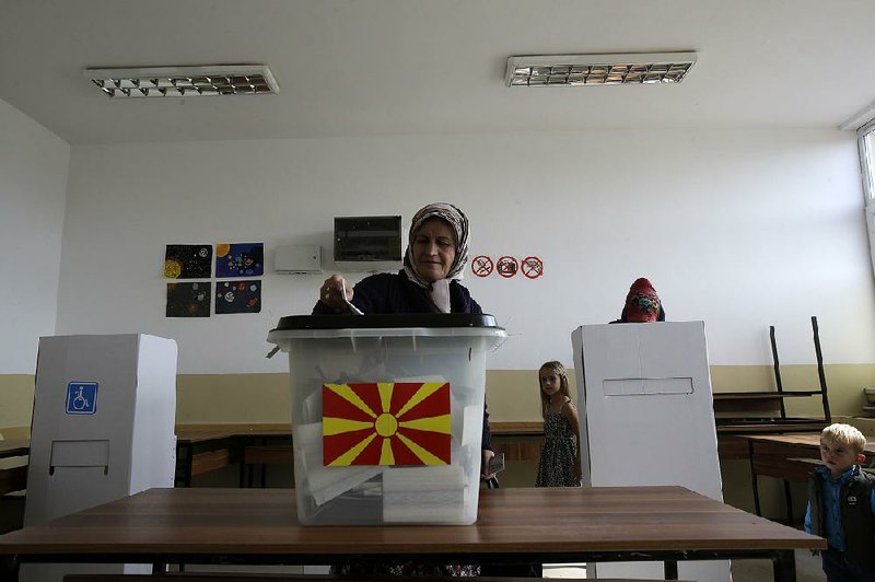 A woman casts her ballot at a polling station during a referendum to decide the country’s future in the village of Aracinovo, near Skopje, Macedonia, on Sunday.