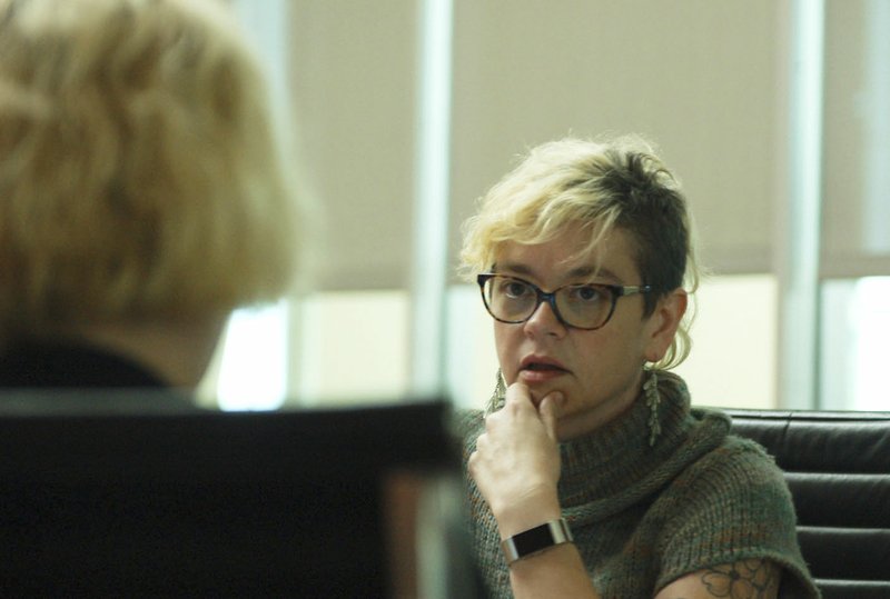 NWA Democrat-Gazette/STACY RYBURN Courtney Burnett, community liaison with Hark at the Center for Collaborative Care, speaks Friday with a prospective client at the Fayetteville Public Library. Hark is partnering with the city on a Help a Neighbor Fund, which will serve as another option for those seeking assistance or those who want to help.