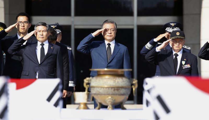 South Korean President Moon Jae-in, center, salutes during the repatriation ceremony for the remains of 64 South Korean soldiers killed in North Korea during the Korean War, which arrived at Seoul Air Base in Seongnam, South Korea, from Hawaii on Monday, Oct. 1, 2018. They were earlier found in North Korea during a joint 1996-2005 excavation project between the United States and North Korea before forensic identification tests in Hawaii confirmed they belong to South Korean war dead, according to Seoul's Defense Ministry. (Bae Jae-man/Yonhap via AP)