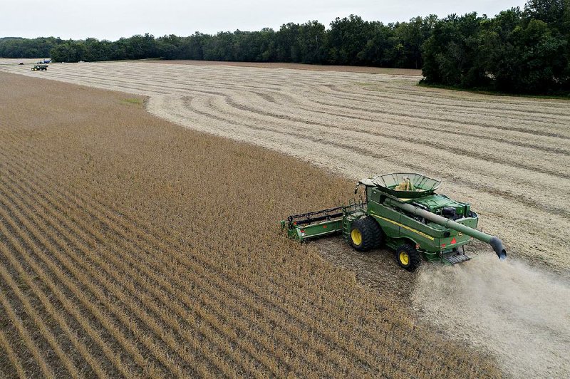 A combine harvests soybeans Tuesday in a field near Tiskilwa, Ill. China has put a heavy tariff on soybeans among other goods. 