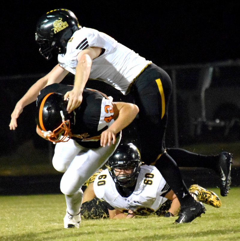Westside Eagle Observer/MIKE ECKELS Graham Guenther (Prairie Grove 2) goes over the top of Lions' quarterback Tajae White (12) for a tackle during the first quarter of the Gravette-Prairie Grove conference football contest in Gravette Sept. 28.