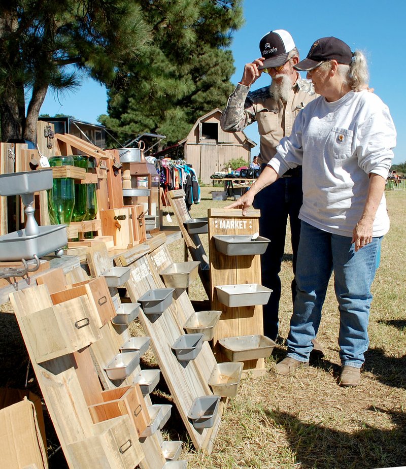 Janelle Jessen/Herald-Leader Vendors Guy and Shirley Ellis of Watts, Okla., set up their crafts at the sale at the intersection of Arkansas Highway 59 and Cheri Whitlock Drive.