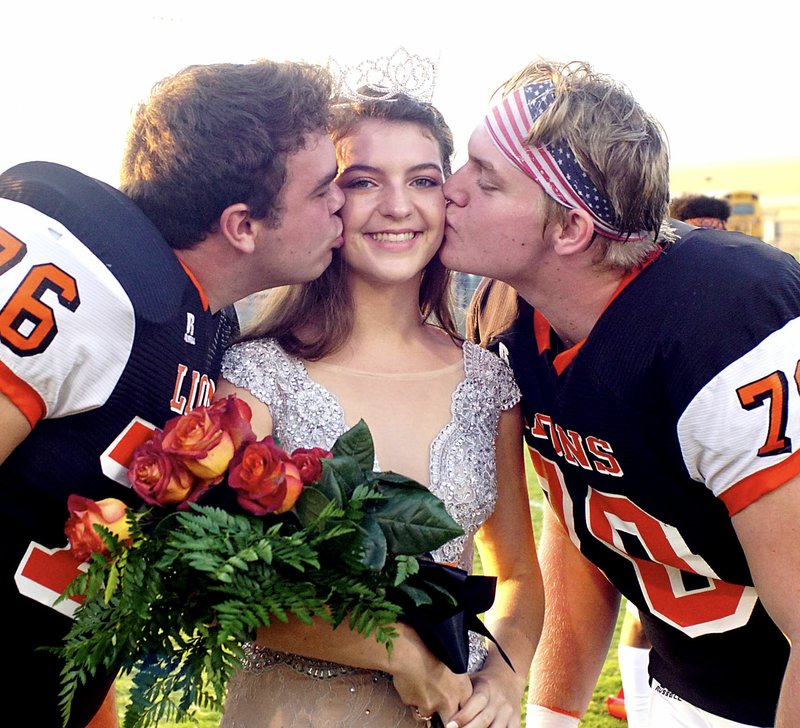 Westside Eagle Observer/RANDY MOLL After being crowned Gravette homecoming queen at Friday night ceremonies at Gravette High School, Hannah Westrick receives a ceremonial kiss from her escorts, seniors Beau Hamilton and Aidan Patton.